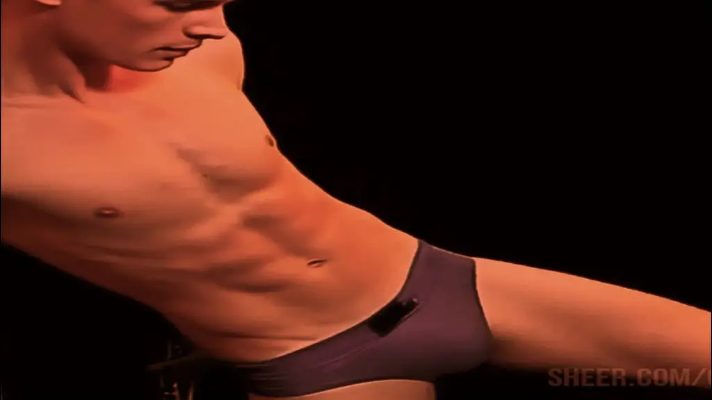 working out with leg stretches and moves in tight blue briefs with sweet bulge. - young man with a well-defined, muscular physique, toned torso and arms. full of joy and excitement