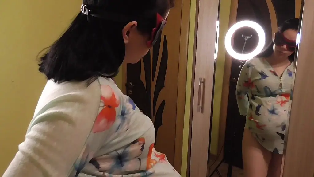 pregnant anna trying on dresses in front of a mirror