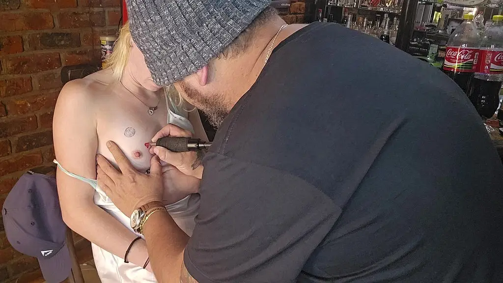 blonde babe gets tattoo on her nipple